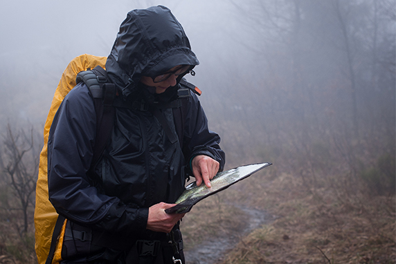 Person navigating with a map in heavy fog