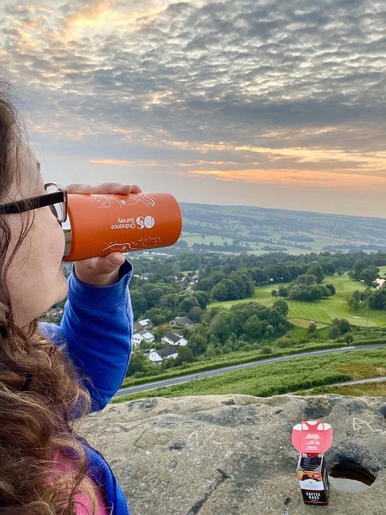 sunrise view - 'Young woman sips a hot drink from an orange mug overlooking a sunrise view of Ilkley moor in Yorkshire.' Andrea Day_ Ilkely Moor_the cow and calf at sunset_IMG_1352