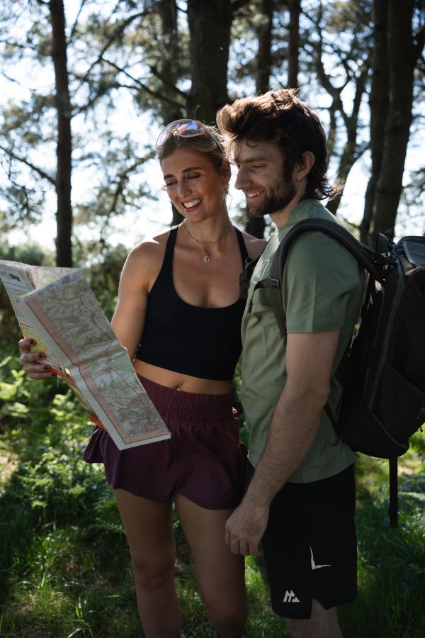 Tristan and Chloe looking at a map in woodland