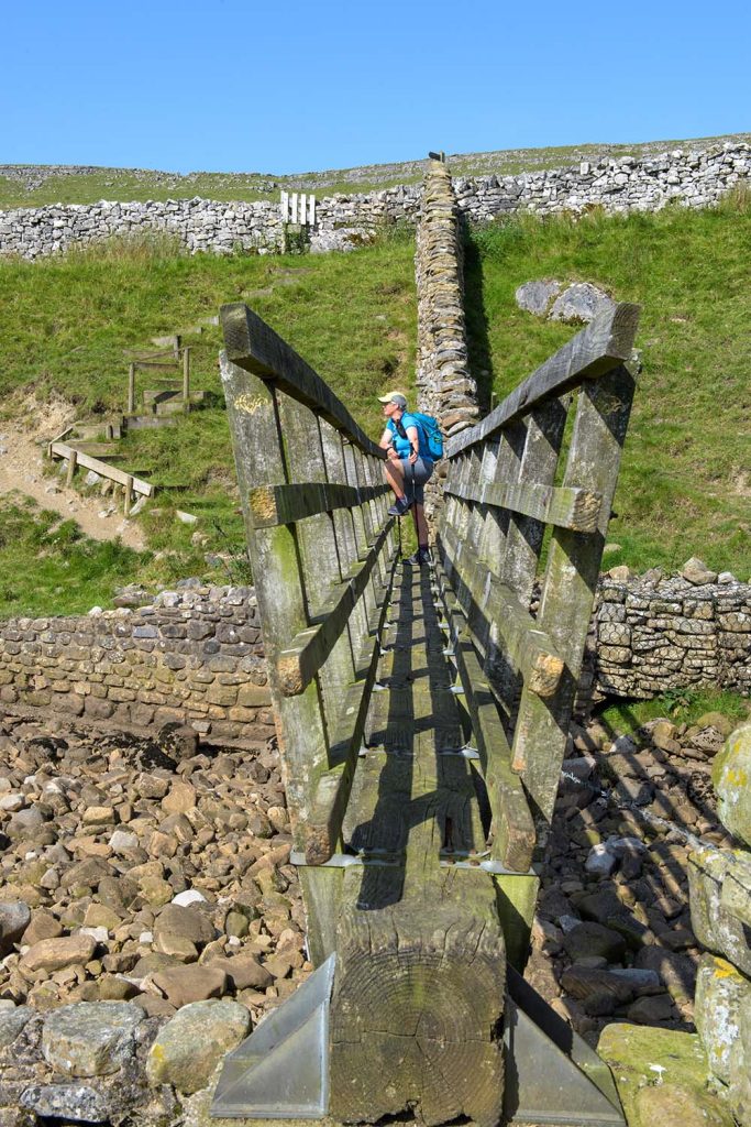 Yorkshire Three Peaks Hannah Collingridge - author on bridge stretching hip Joolze Dymond