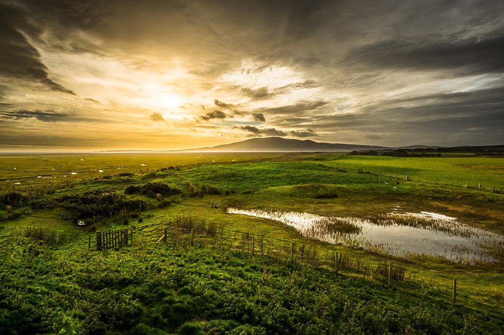 View over wetlands near Caerlaverock in Scotland with Criffel Hill in the background.