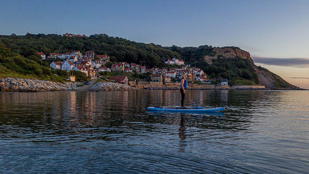 Charlotte Graham
Paddle Boarder Jo Moseley out in the Sunrise Runswick Bay North Yorkshire UK