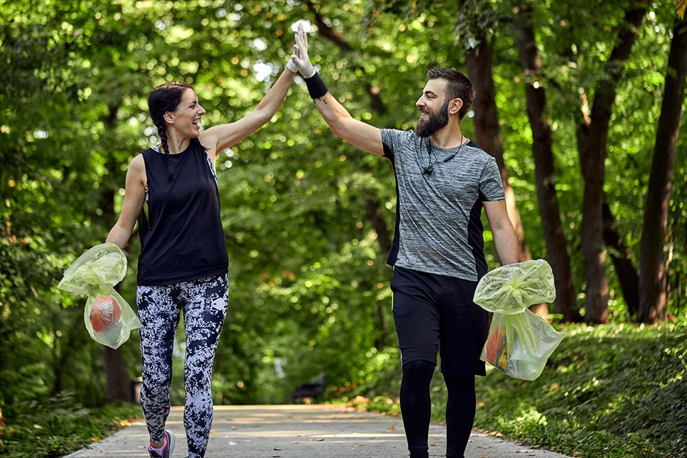 Happy couple plogging on forest path