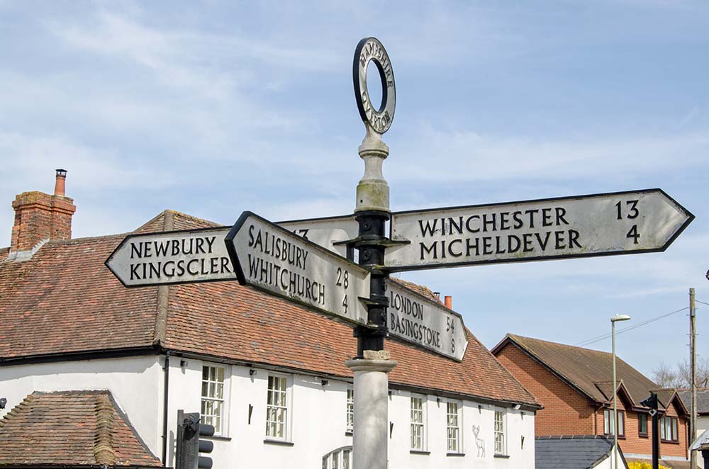 Finger post in the middle of the Hampshire town of Overton pointing towards the main towns and cities accessible from the now sleepy area.