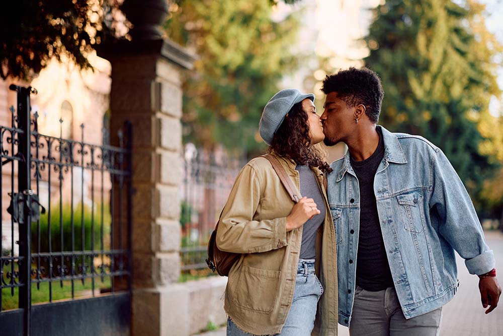 Young romantic couple kissing while walking in the city in autumn.