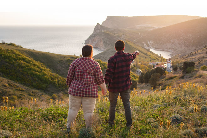 Couple holding hands at the top of a hill