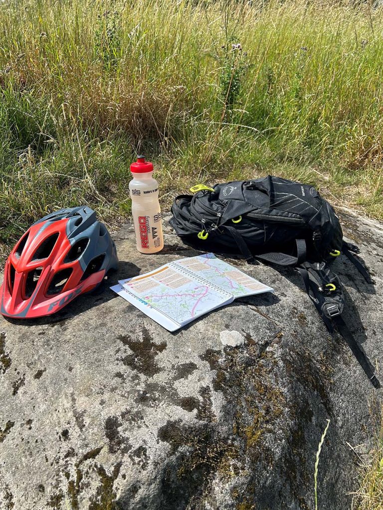 bike helmet and guidebook on a rock