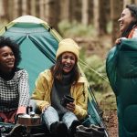 friends camping and laughing in the woods