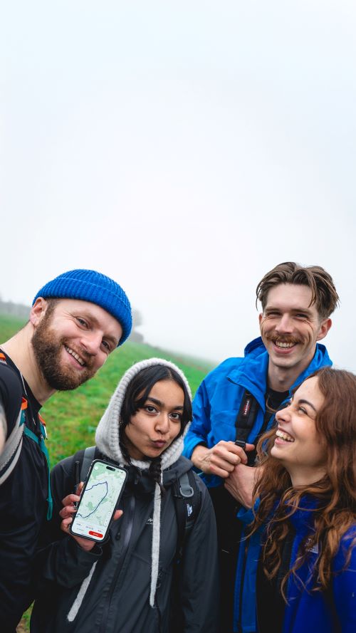 Group of young walkers show a OS Maps mapping app on a phone