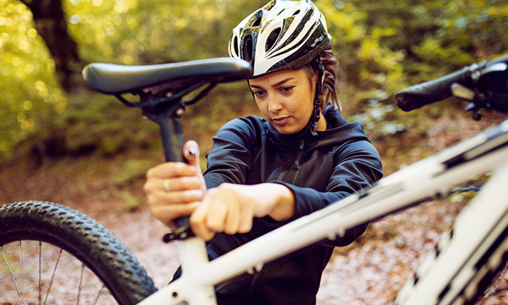 young woman adjusting bike