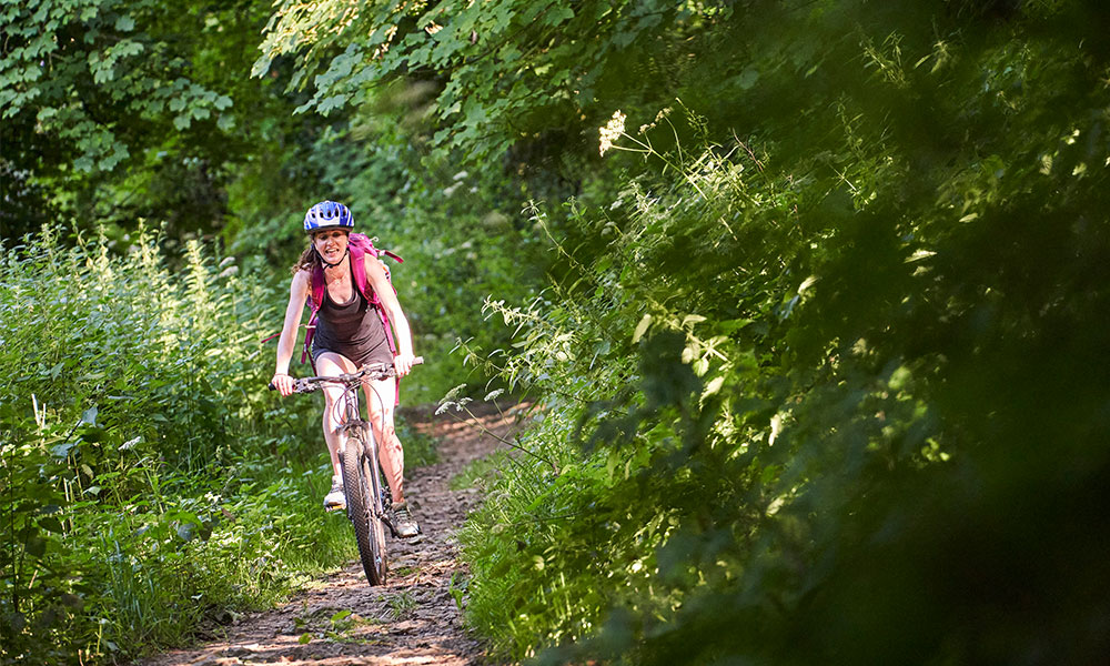 Women cycling through greenspace