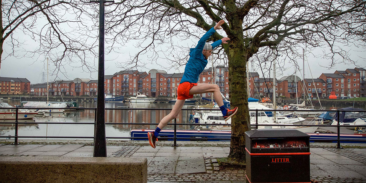 Rory jumping across street furniture on his running route around Preston Docks